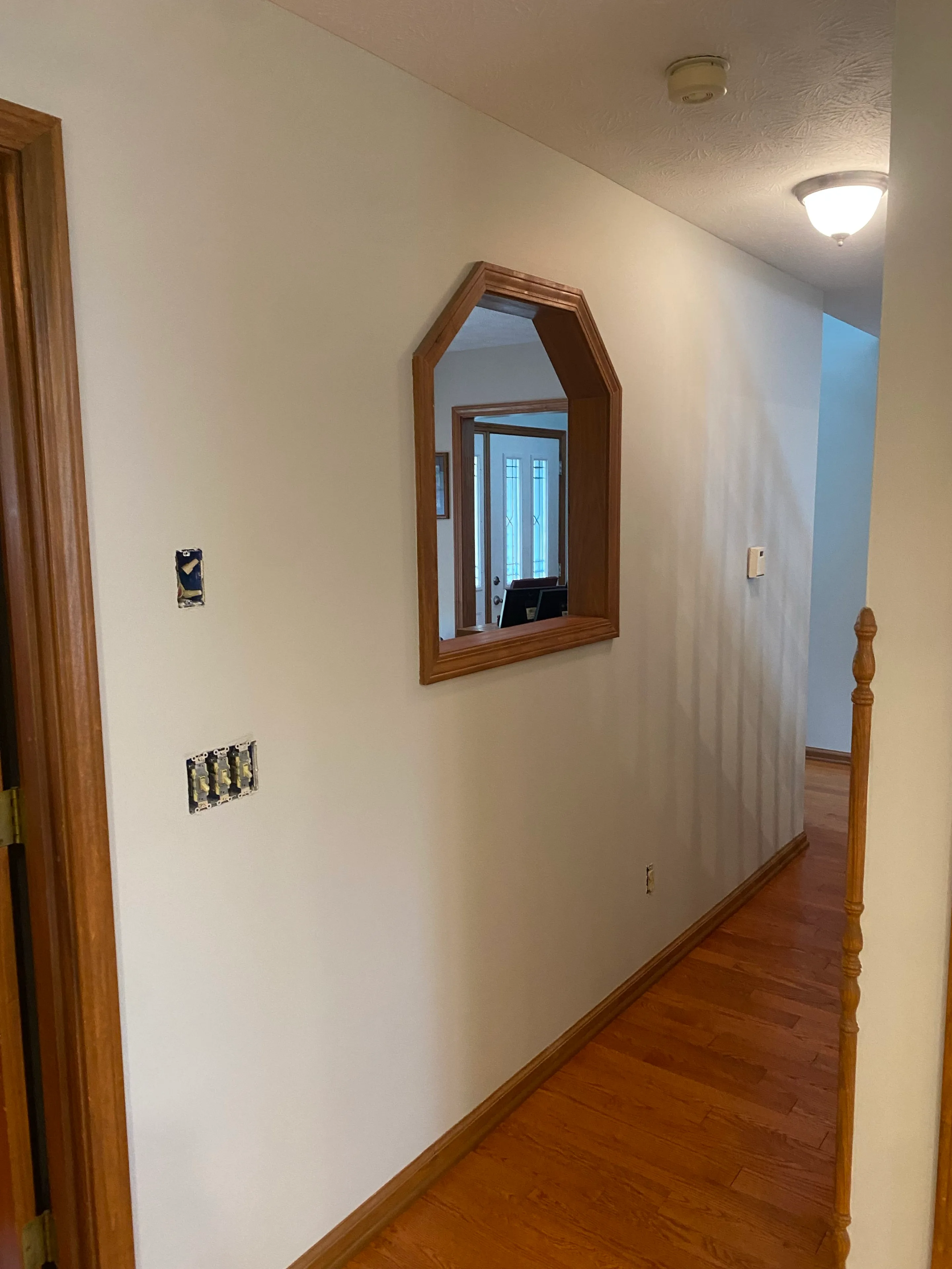 Freshly painted hallway walls with clean lines around existing natural woodwork